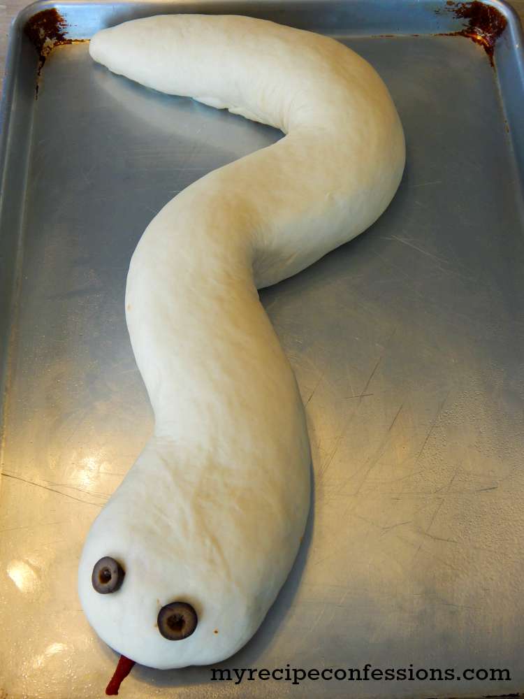 Pizza Stuffed Snake- This easy to follow recipe and tutorial is my boys favorite! You can customize it with your favorite pizza toppings. My kids love to help paint the snake. You will be shocked how simple the food coloring paint is to make. This snake is a great main dish to serve at a Halloween party, birthday party, or Harry Potter party. Serve it with a side of blood a.k.a marinara sauce for a huge party hit! 