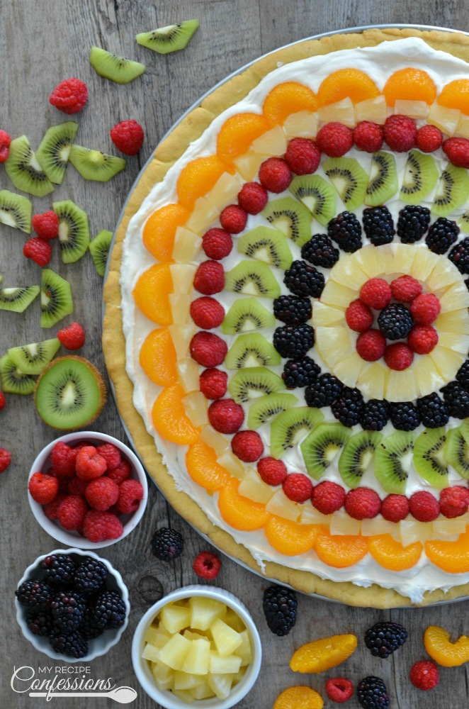 Easy Classic Fruit Pizza is an easy recipe that uses the best sugar cookie recipe for the crust. The cream cheese frosting tastes just like cheesecake. This gorgeous dessert is absolutely divine!